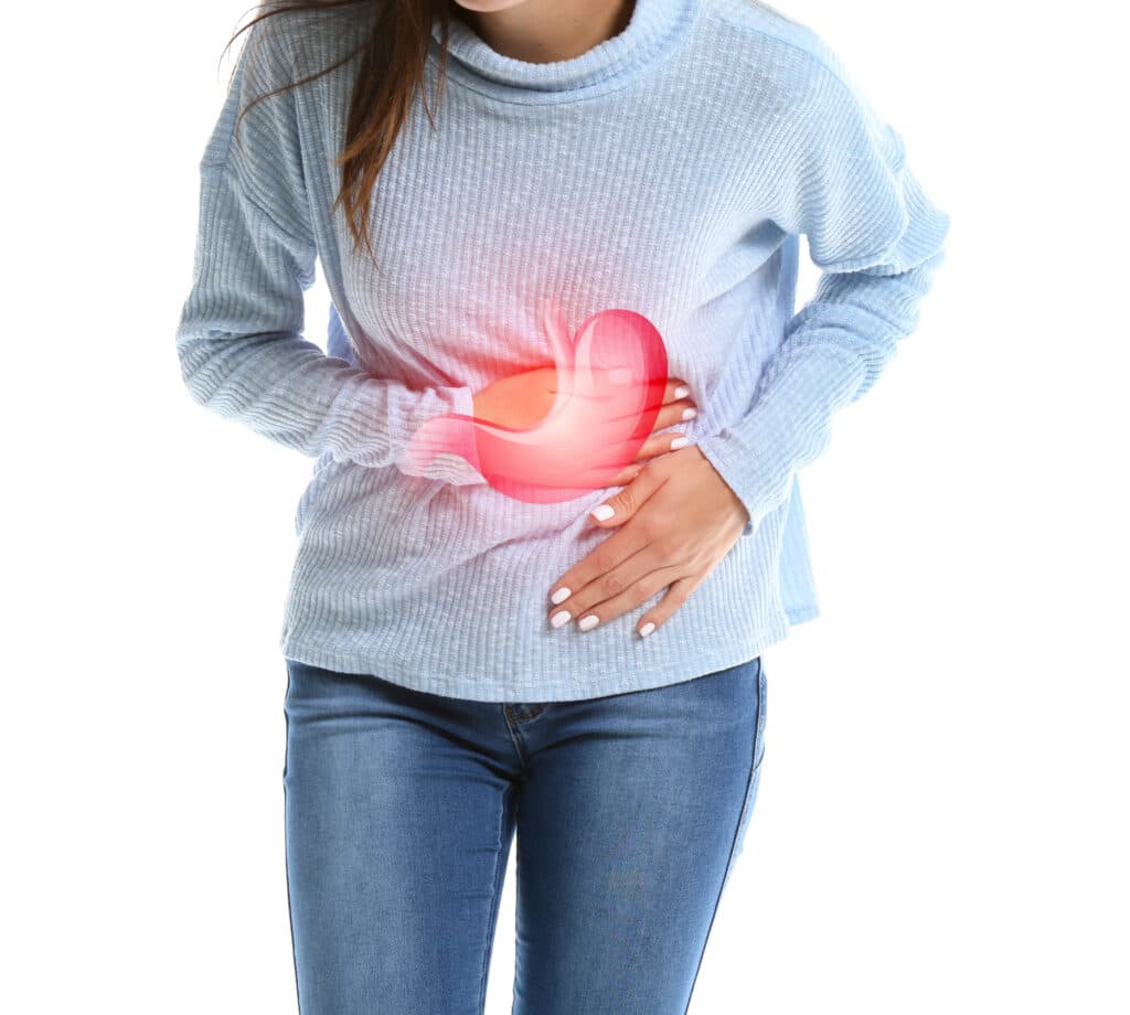 Women holding stomach suffering from low stomach acid symptoms